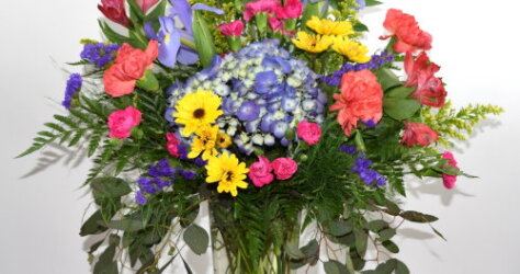 Flower arrangement with Blue Hydrangea, Red Alstromeria, Blue Iris, long lasting carnations and mums.