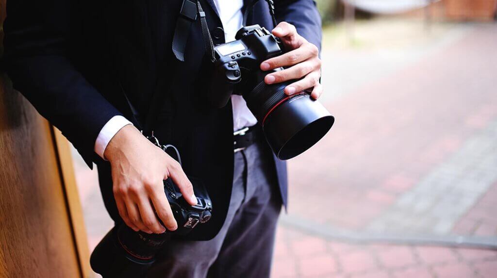 Wedding photographer holding professional cameras