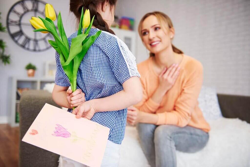 Child Surprising Their Mother With A Bouquet Of Flowers